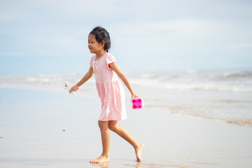 Fototapeta na wymiar Asian little child girl playing with toys on the beach
