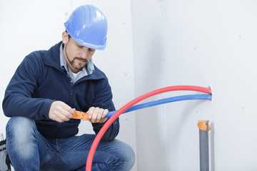 man in hardhat using cables