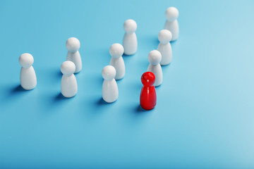 Obraz premium The leader in red leads a group of white employees to victory, HR, Staff recruitment. The concept of leadership.