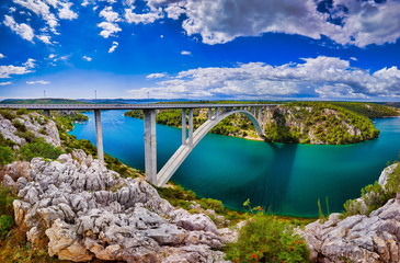 Sunlight view on the Sibenik Bridge a long concrete arch bridge passing through the canyon of the Krka River. Location Skradin town, Croatia, Europe. Travel destination. Discover the beauty of earth.