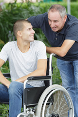 son in wheelchair and father on a walk