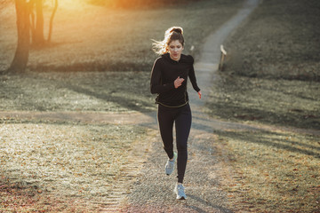 Young athlete exercise at the park. Young woman running at the park