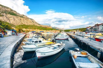 Fototapeta na wymiar Famous Adriatic resort Makarska with picturesque harbor and touristic boats
