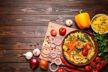 Flat lay composition with tasty rice pilaf on wooden table. Space for text