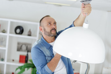 electrician at work installing lamp on the wall