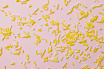 Colorful sprinkles on a pink background, top view with copy space. Easter holiday. Birthday celebration.
