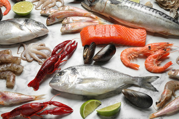 Fresh fish and different seafood on white marble table