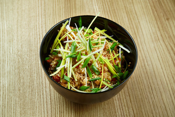 Traditional street-food Vietnamese rice with vegetables and meat in a black bowl. Delicious food close up