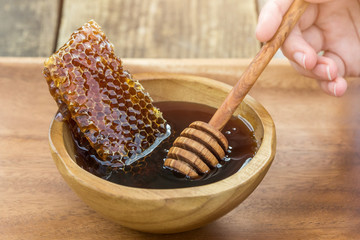 a large piece of honeycomb in a wood bowl filled with fresh and sweet organic honey