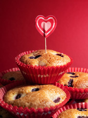 Muffins with blueberries and raspberries. Cupcakes with Valentine's Day decor. Red velvet cupcakes in bright colorful setting on a red background.