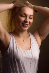 Portrait of a blonde in white dress on a light golden background