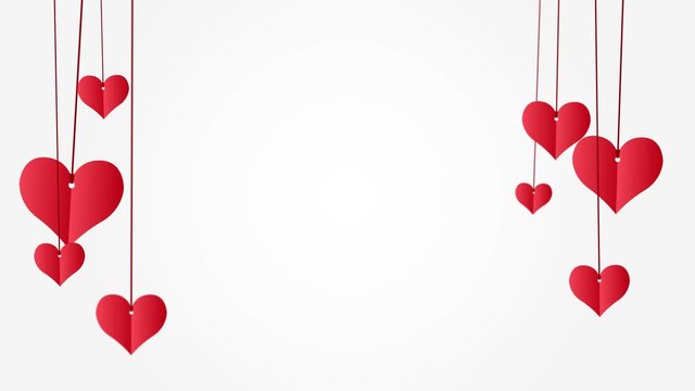 Red paper hearts hanging on red string with copy space on white background