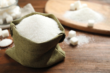 Granulated sugar in sack on wooden table