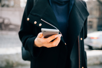 Young unrecognizable woman dressed in black coat