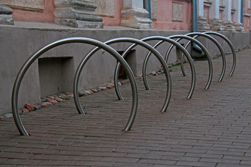 parking spaces for bicycles in the form of metal hoops dug into the ground © Sergey