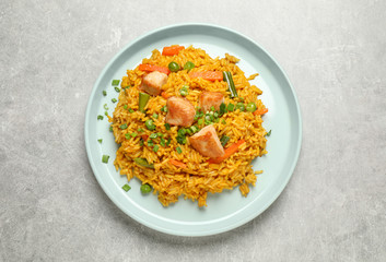 Delicious rice pilaf with vegetables on light grey table, top view