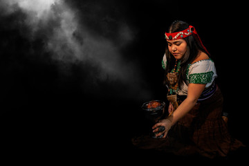 young woman Shaman ,with sahumerio in the hands , curandera, Olmec facilitator, Teotihuacana, Xicalanca - Toltec in black background, with pre-Hispanic dress,mystical smoke environment