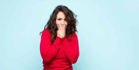 young pretty woman happy and excited, surprised and amazed covering mouth with hands, giggling with...