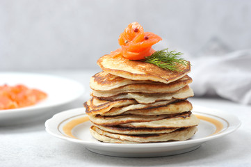 Fritters with salted salmon. In the background is a plate with slices of salmon.  close-up.  Macro shot.