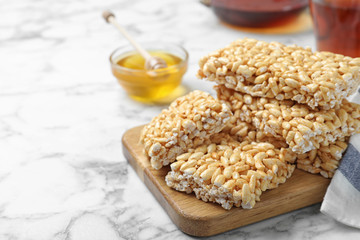 Delicious rice crispy treats on white marble table, closeup. Space for text