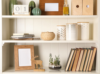 White shelving unit with books and different decorative elements