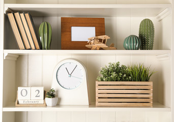 White shelving unit with clock and different decorative elements