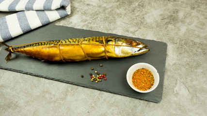 Appetizing smoked fish on kitchen board.Smoked fish with spices