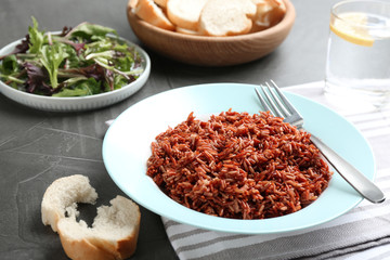 Tasty brown rice served on dark grey table