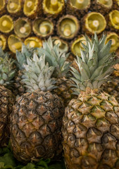 Close up of pineapples (and sliced fresh pineapples) at a local market. Healthy vegetarian food.
