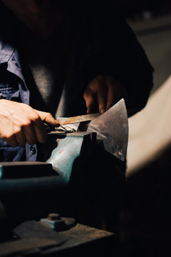 Crop craftsman checking axe in workshop