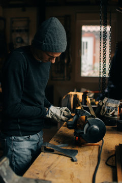 Crop craftsman checking axe in workshop