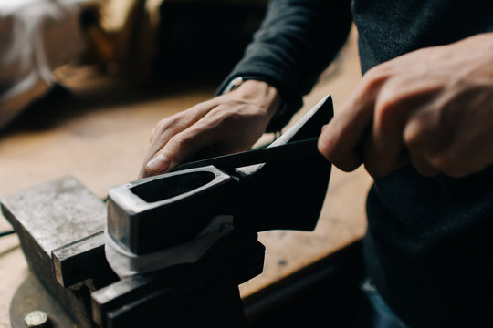 Crop craftsman checking axe in workshop