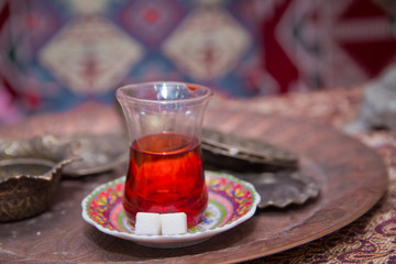 Tea in Azerbaijani traditional armudu pear-shaped glass . Azerbaijan black tea .white sugar cubes . Black turkish tea in pear shape glass, traditional Azerbaijani aromatic tea in armudu cup .