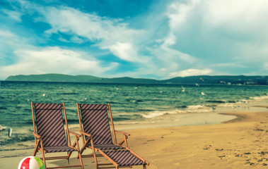 Seascape view of beach facing out to the ocean wooden beach chairs put on the beach.