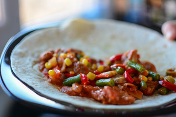 Close-up, making tacos at home in kitchen. Selective focus