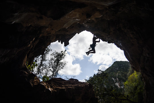 A man rock climbing in a cave. 