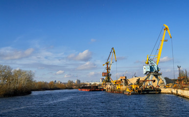 two cranes stand on a pier in the port