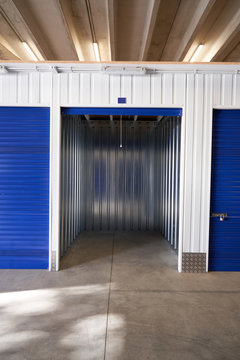 Inside industrial self storage building for rental with blue locked doors