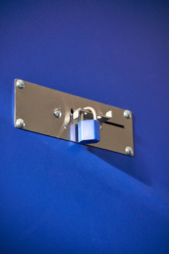 Blue padlocks locking a blue storage door