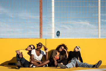 Cheerful young diverse female friends celebrating meeting in city