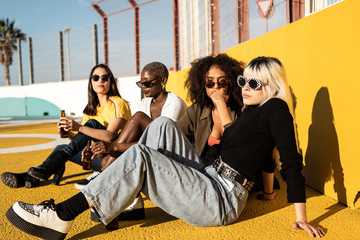 Cheerful young diverse female friends celebrating meeting in city