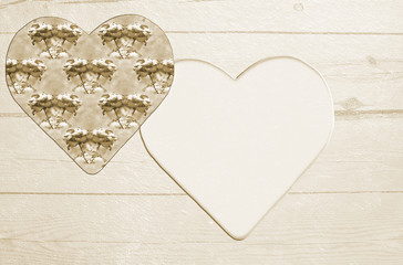 Two hearts on a textured wooden background. Sepia-toned