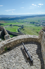 View from the walls of the Spiš Castle (Spišský Hrad) with a cannon defending the walls and view of the Spišské Podhradie town beneath, Slovakia
