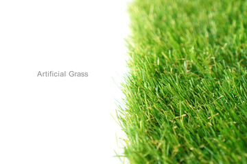 Green artificial grass on a white background, copy space.