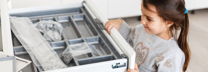 Little baby helping to assemble a kitchen in a new home