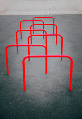 Red sports equipment stick out of the ground in a checkerboard pattern for snake running  around