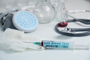 medical laboratory test tube with the word coronavirus test and syringe with blood inside,...