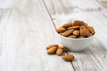 Almonds seed in the white bowl on wood table