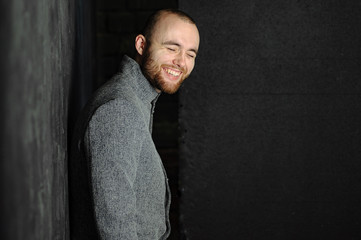 Portrait of happy handsome man in gray suit against gray background.