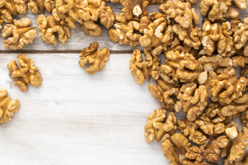 Scattered walnuts on wooden table, stock photo.